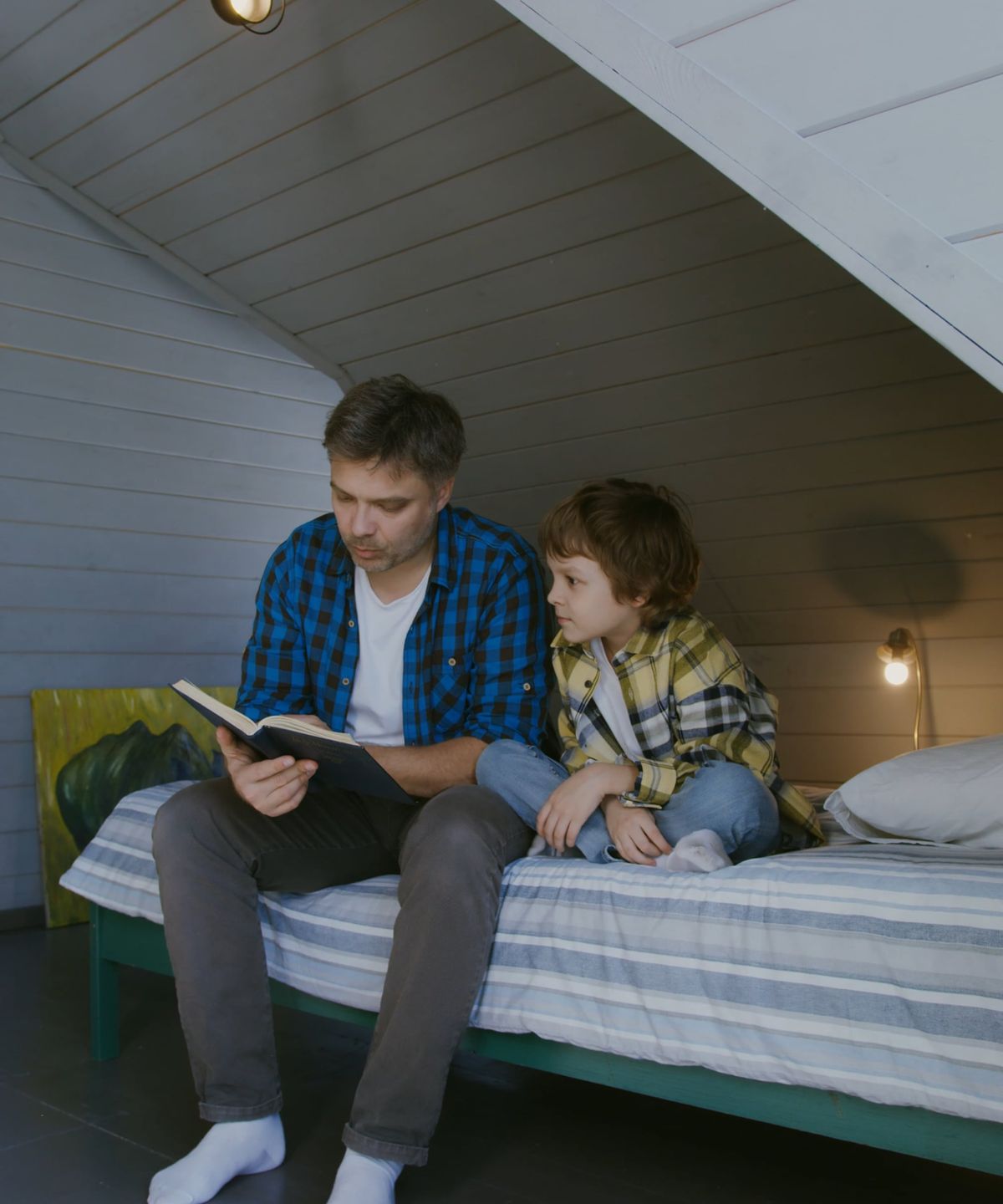 A father reading with his young son at home, building a daily language routine together